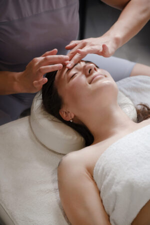 face massage with oil in traditional style made by professional beauty therapist women. anti-age massage